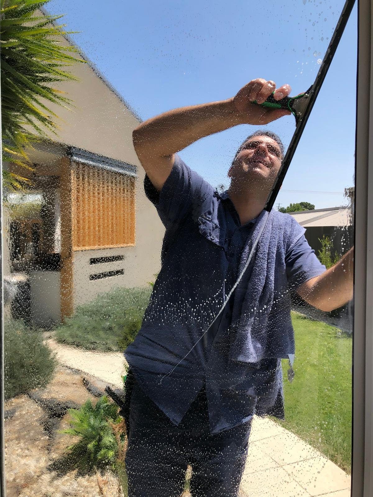 Mint Carpet Cleaning technician squeegeeing an exterior window in Port Macquarie